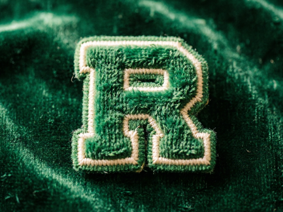 Vintage varsity chenille letter patch with fluffy raised chain-stitch texture in racing green and cream