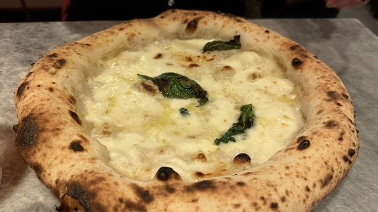 Pizza napolitana de queso con borde inflado de horno de leña