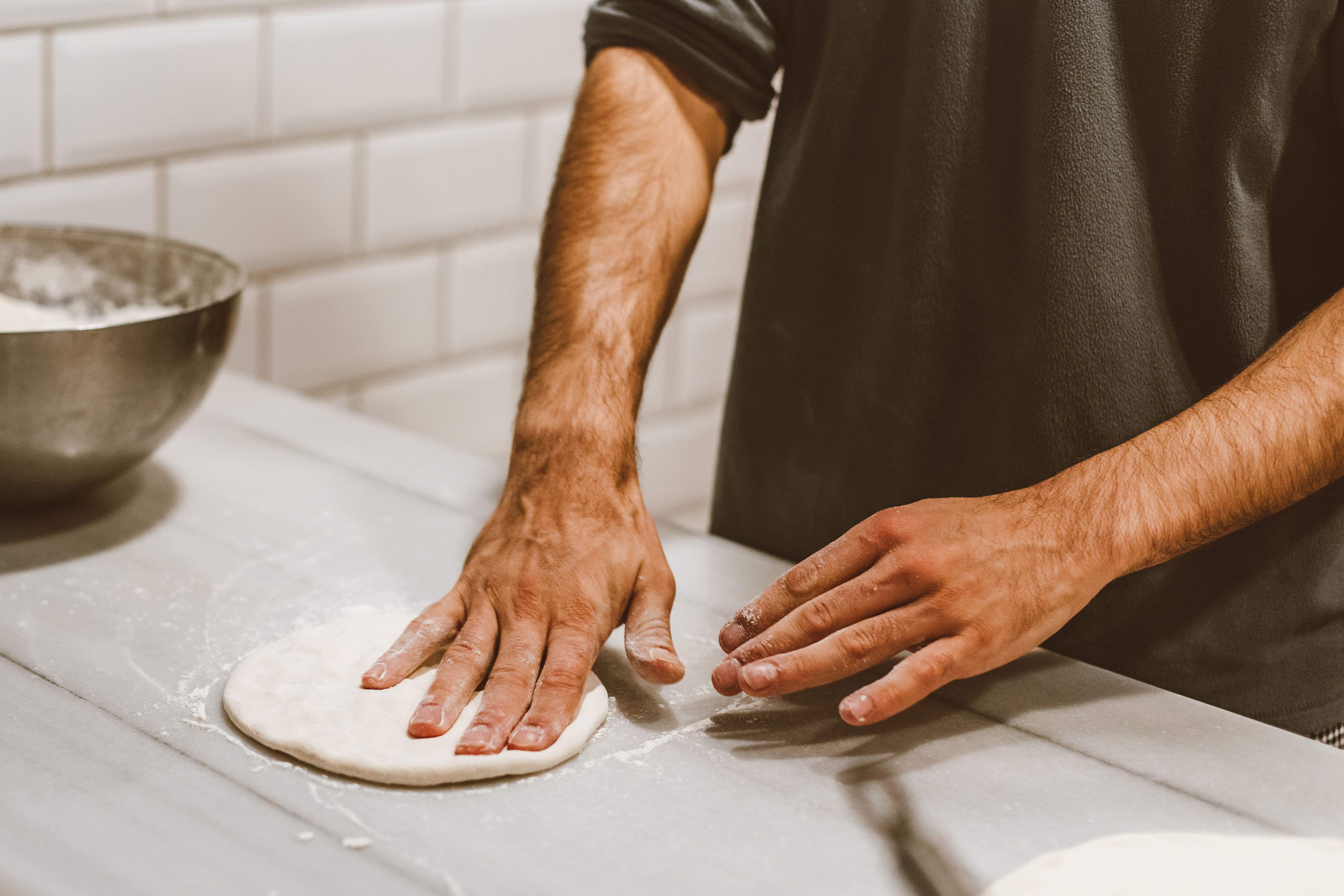 Pizzaiolo estirando el disco de masa a mano