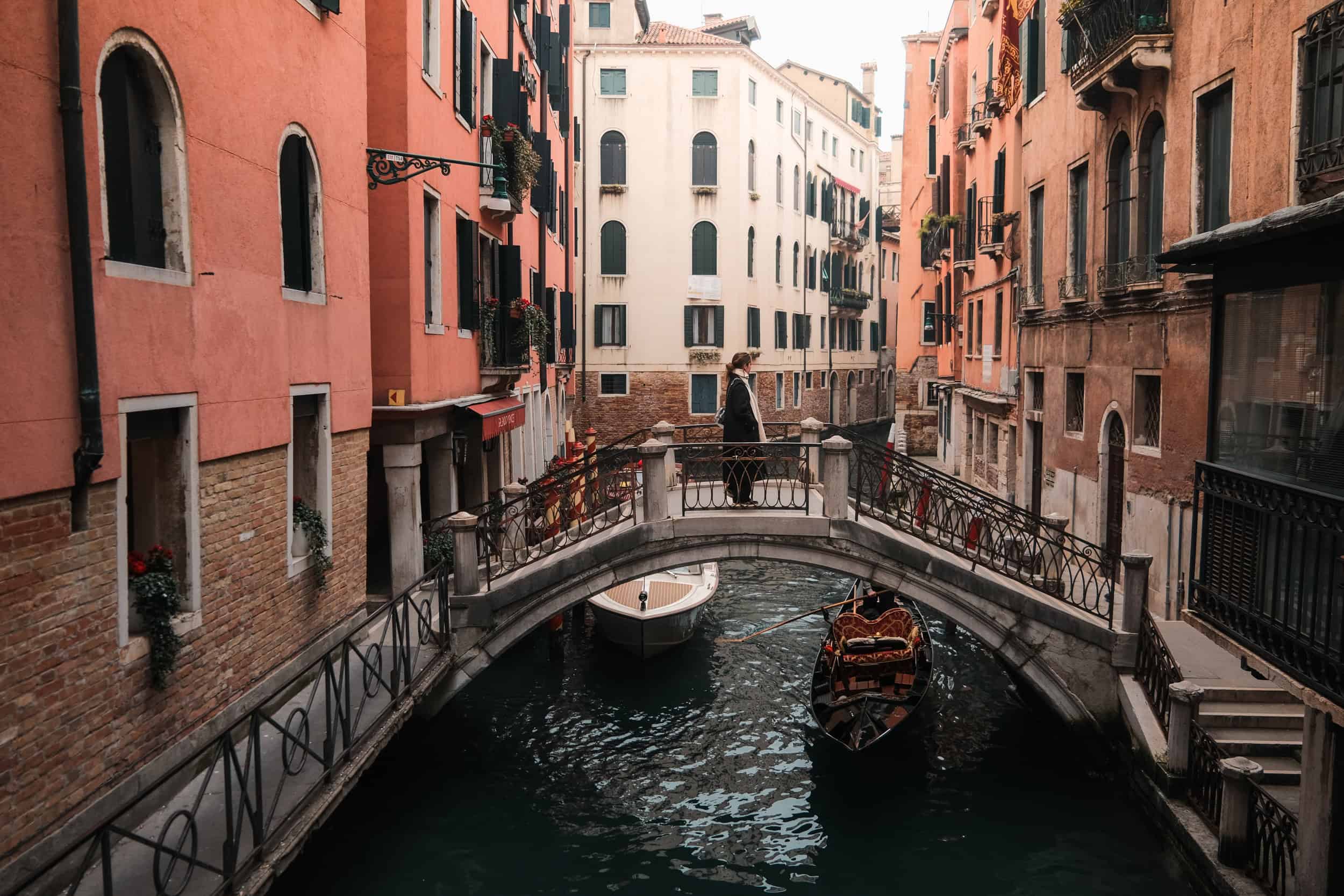 Canal veneciano con góndola y puente en temporada de primavera u otoño