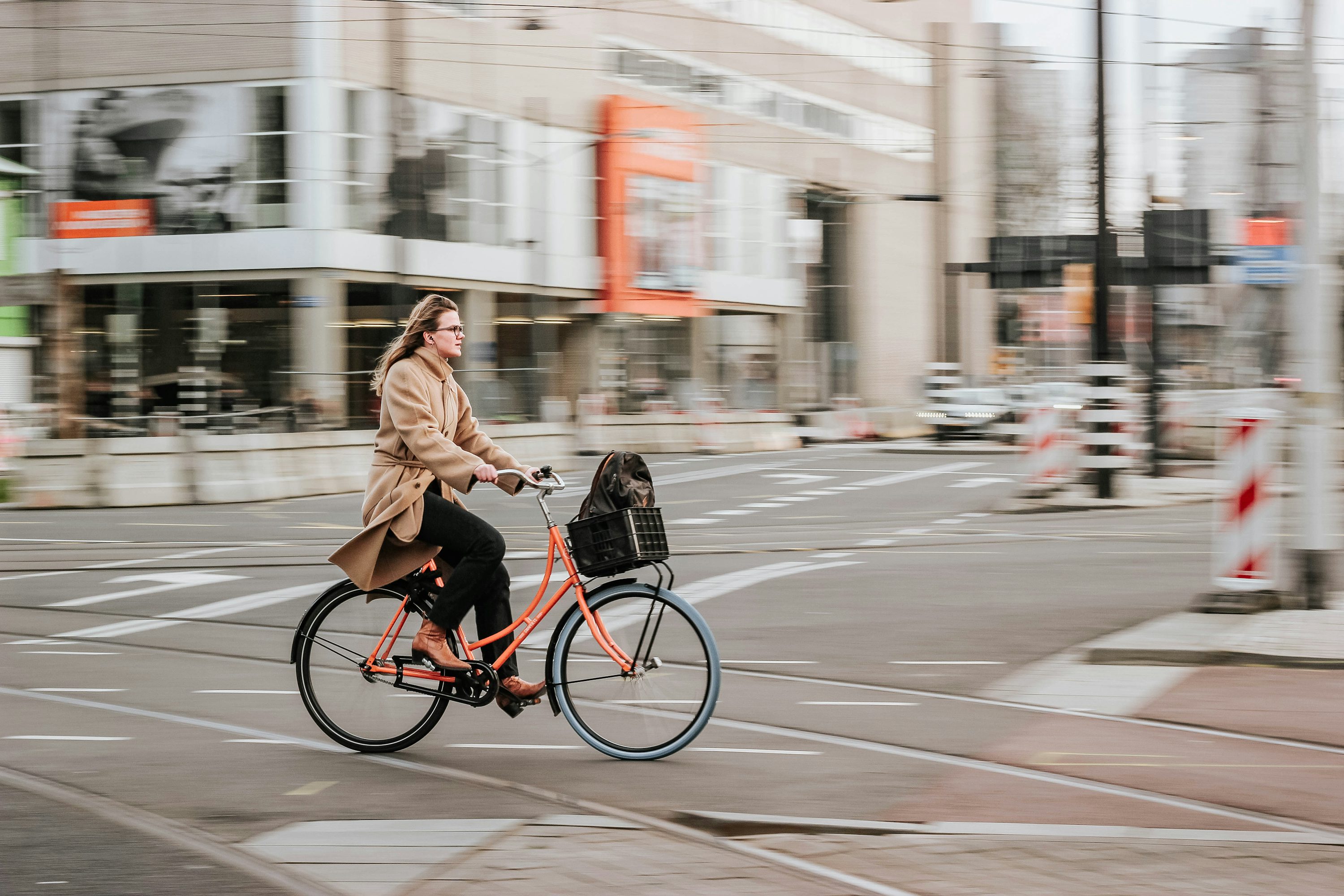 A commuter cycling across Amsterdam tram tracks, the kind of real-street test ride we recommend before buying at e-bike shops for internationals