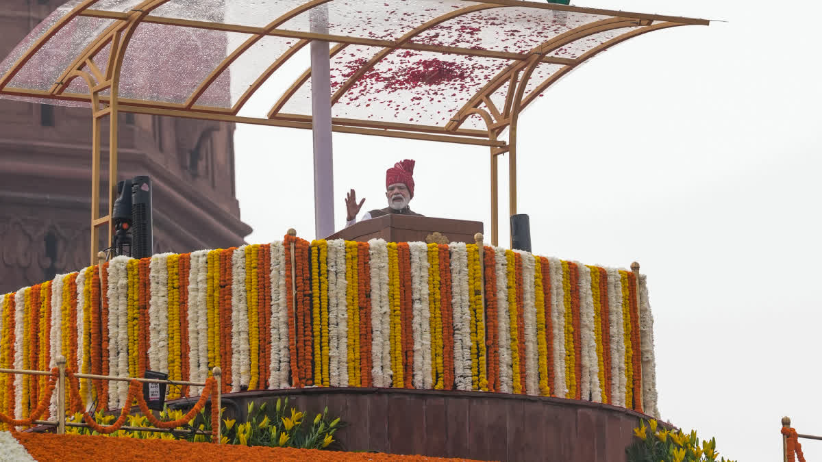 Narendra Modi greeting the crowd from the flower-decorated Red Fort ramparts after the Independence Day address