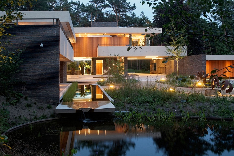 The Mercer Residence — contemporary villa at dusk, warm glass walls reflected in a still pond