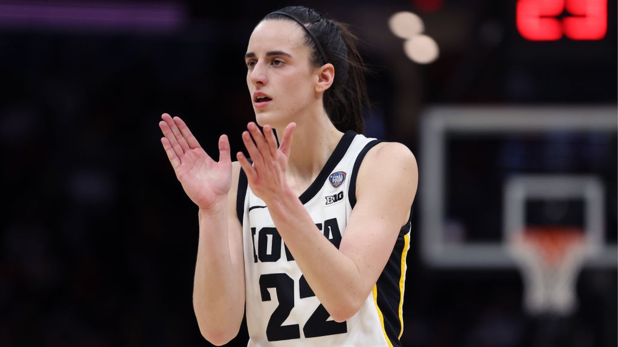 Caitlin Clark in her Iowa Hawkeyes jersey applauding during the 2024 NCAA Final Four run