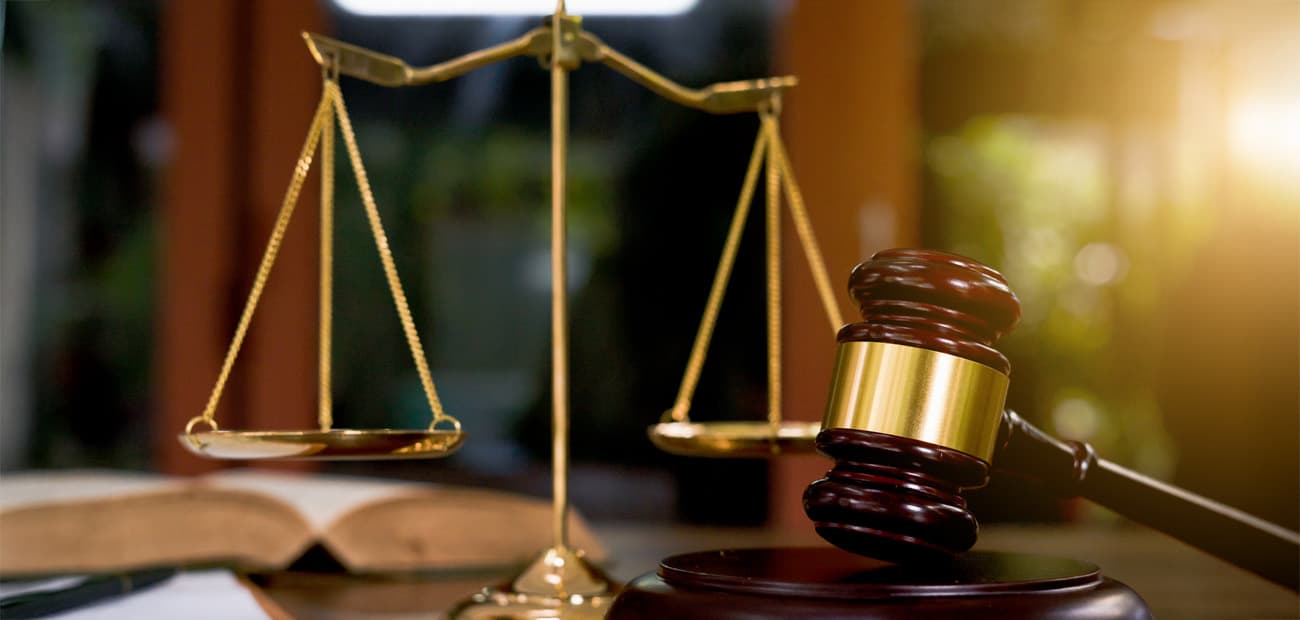 A wooden gavel and brass scales of justice representing the federal trade dress ruling against Rebel Creamery