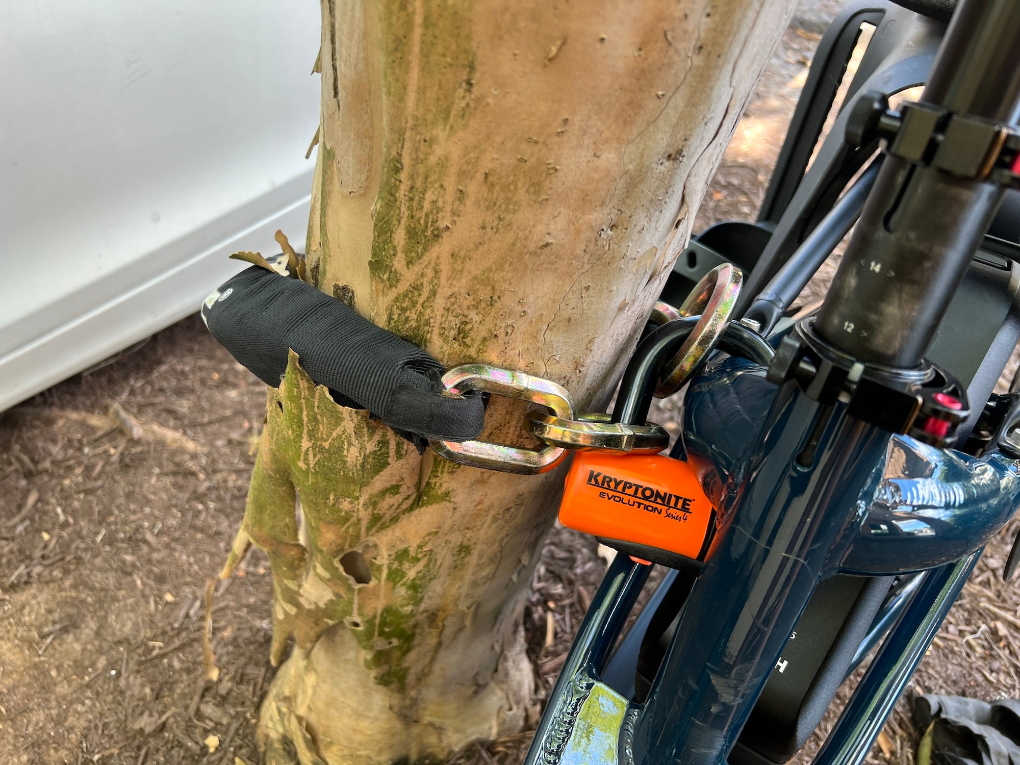 An e-bike anchored to a fixed post with a heavy chain and U-lock, the combination that deters e-bike theft in the Netherlands