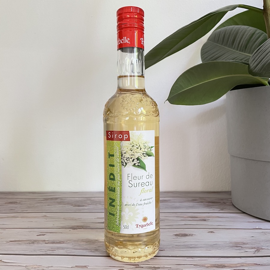 Sirop artisanal à la fleur de sureau entouré de feuillage