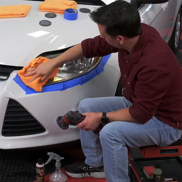 Headlight restoration polishing on cloudy car headlamp