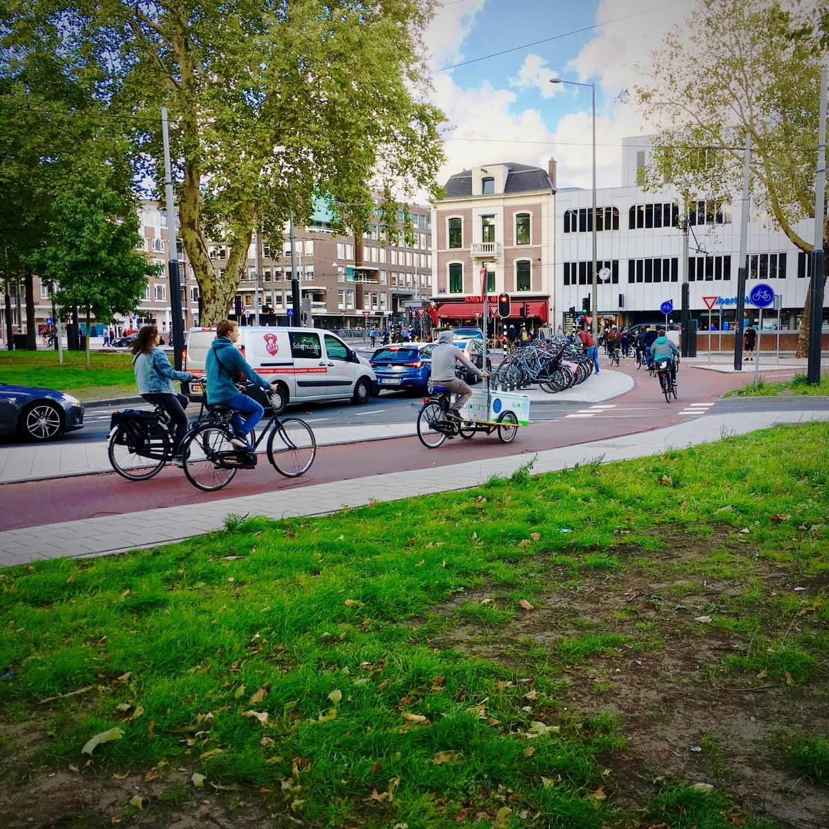 Commuters cycling on a wide Dutch bicycle path, many of them on e-bikes obtained through an e-bike lease Netherlands for employees scheme at work