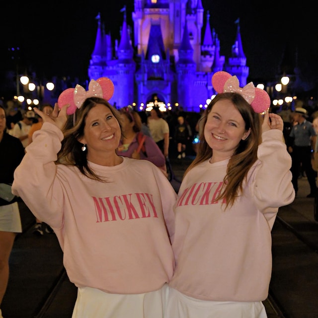 Duas mulheres com orelhinhas rosa à noite no castelo