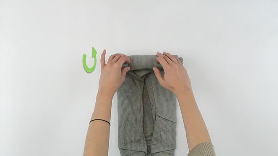 Hands demonstrating the rolling technique on a shirt