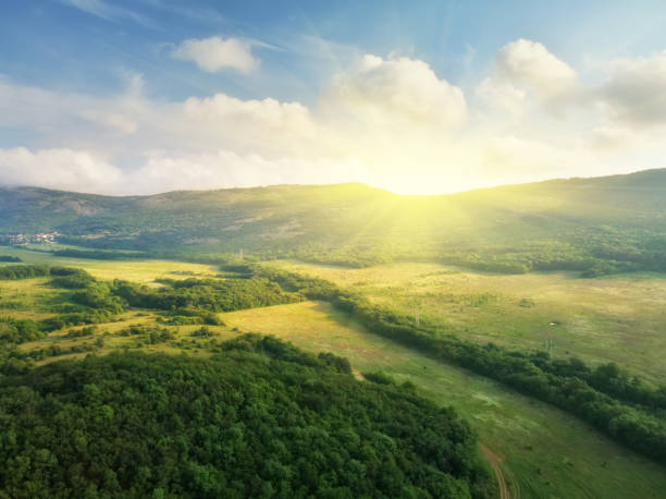 Sunrise breaking over green hills and valleys