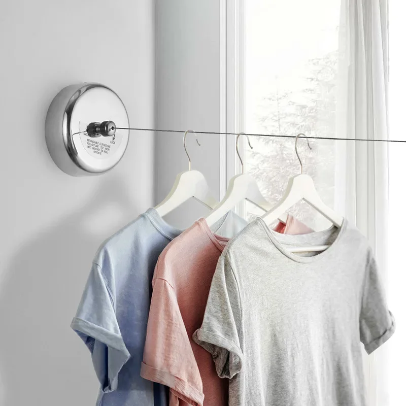 T-shirts hanging on a retractable travel clothesline by a window
