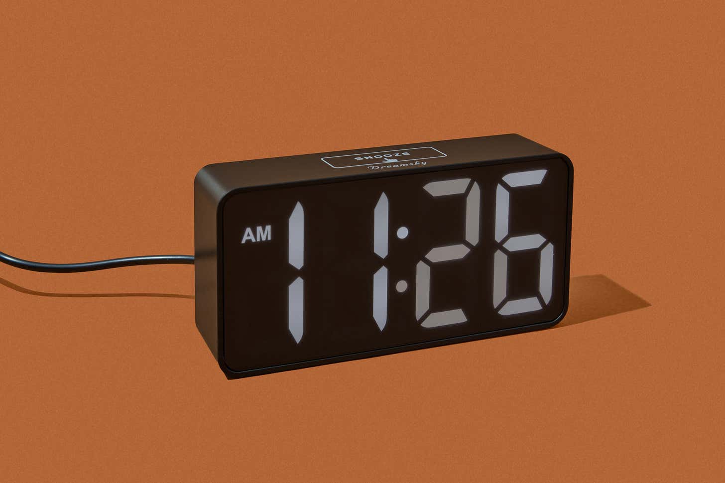 A digital alarm clock glowing in the dark