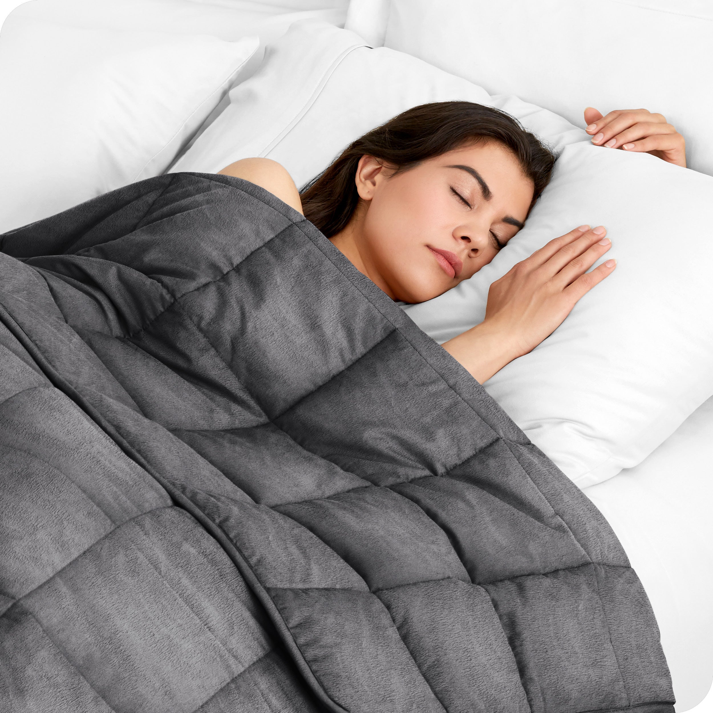 A woman sleeping under a gray weighted blanket