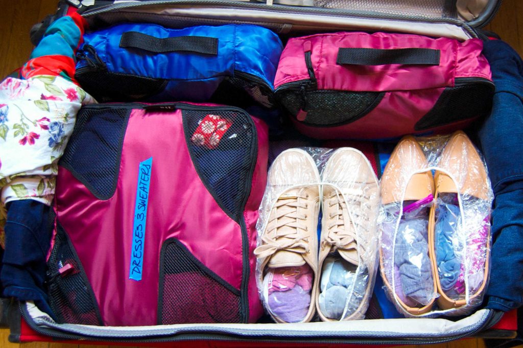 A packed suitcase with shoes wrapped and socks tucked inside them