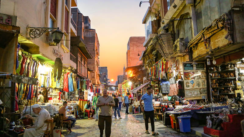 سوق شعبي وقت الغروب والناس ماشية