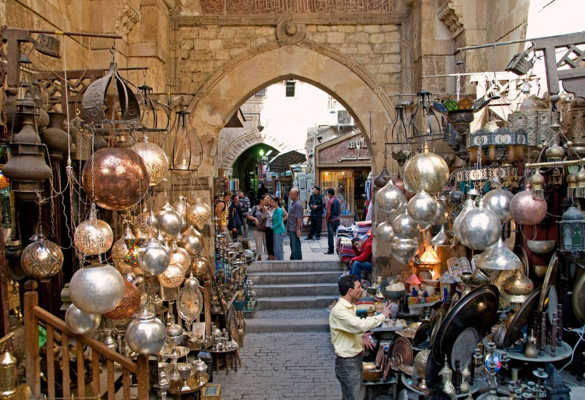 قوس أثري وفوانيس مضيئة والناس