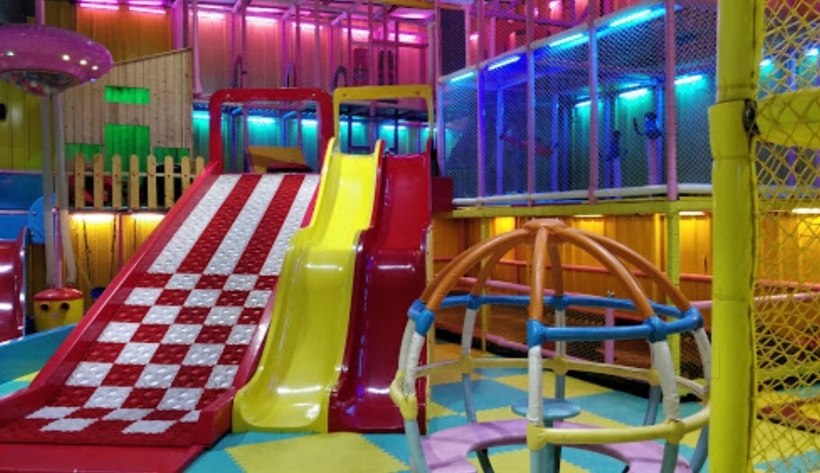 Multi-level soft play structure with slides at kids play area