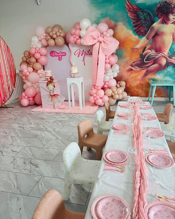 Birthday party decoration setup with balloon arch