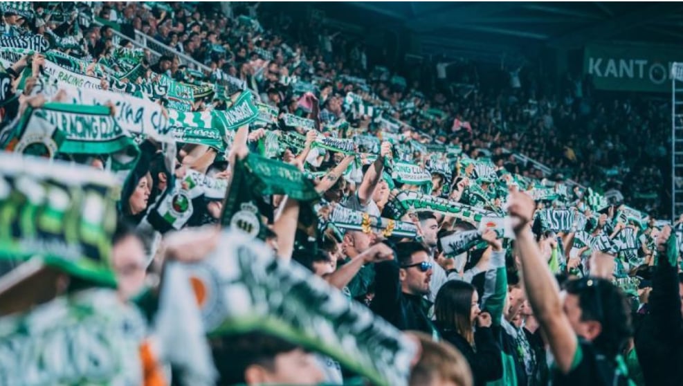 Racing Santander supporters waving green and white scarves in the stands of El Sardinero