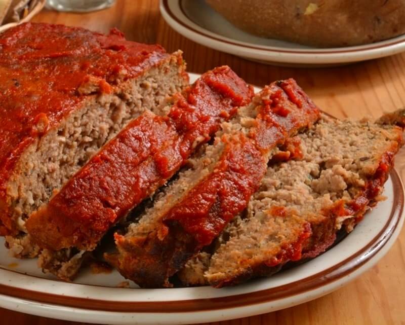 Brenda Gantt's juicy sausage meatloaf sliced and served on a white plate with tomato glaze