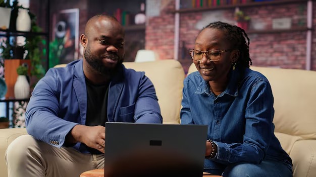 Nigerian mentor guiding a mentee through a business lesson on a laptop