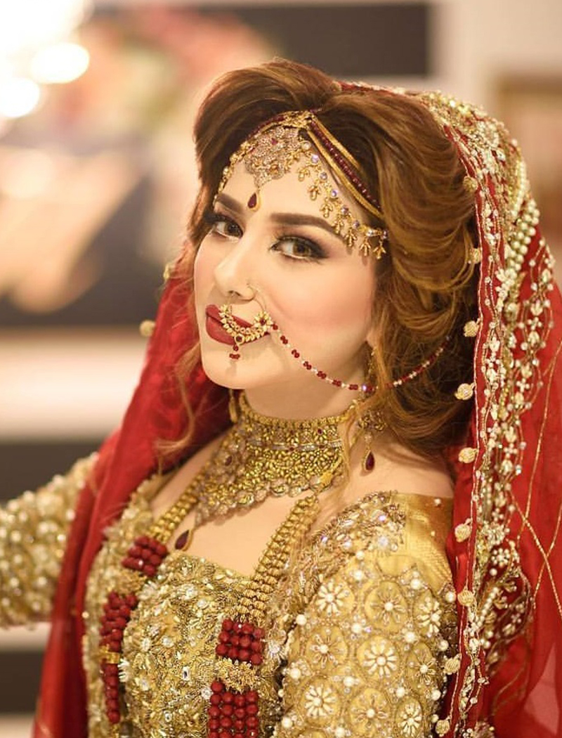 Bride in crimson dupatta with gold jewellery
