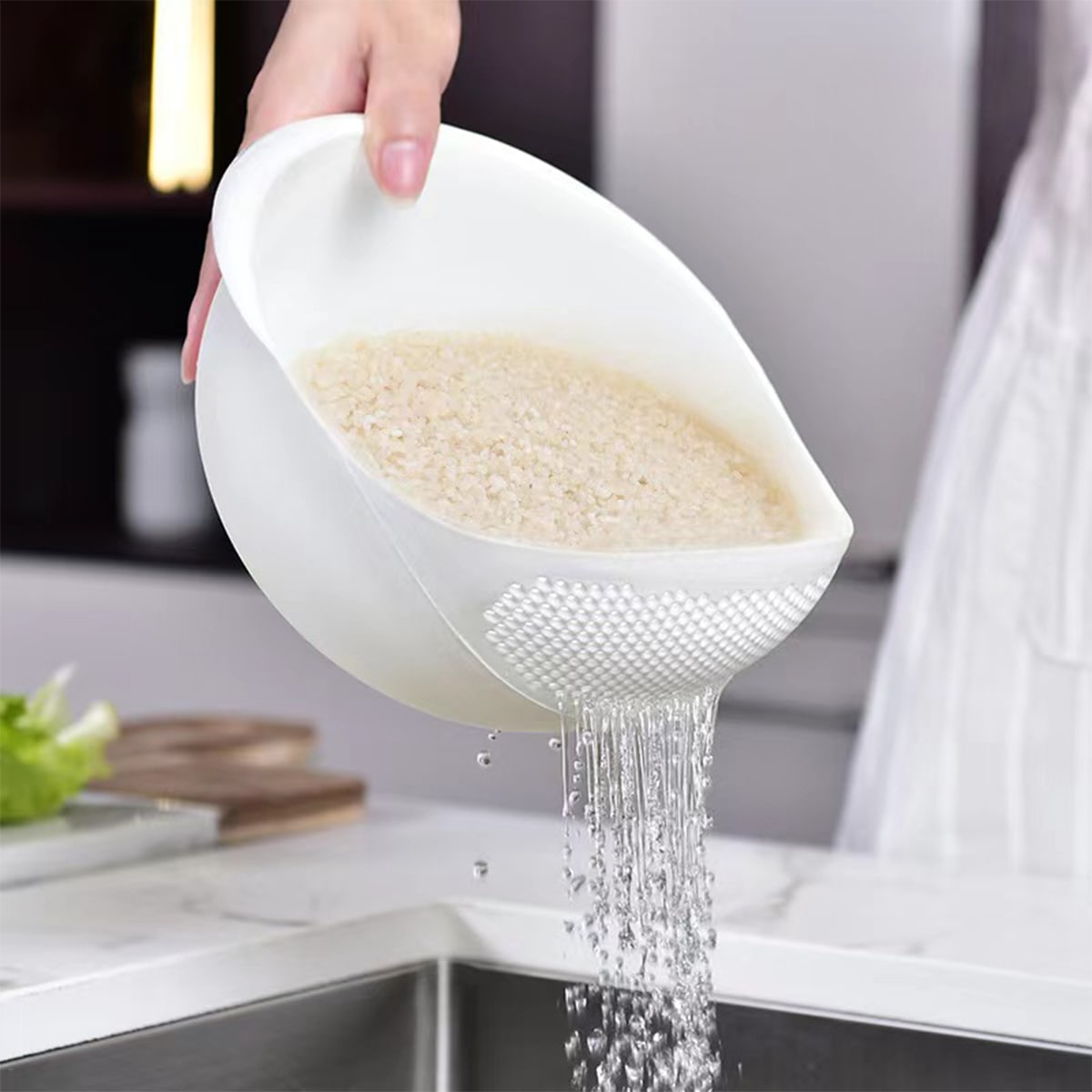 Rinsing rice in fine-mesh strainer under cold water